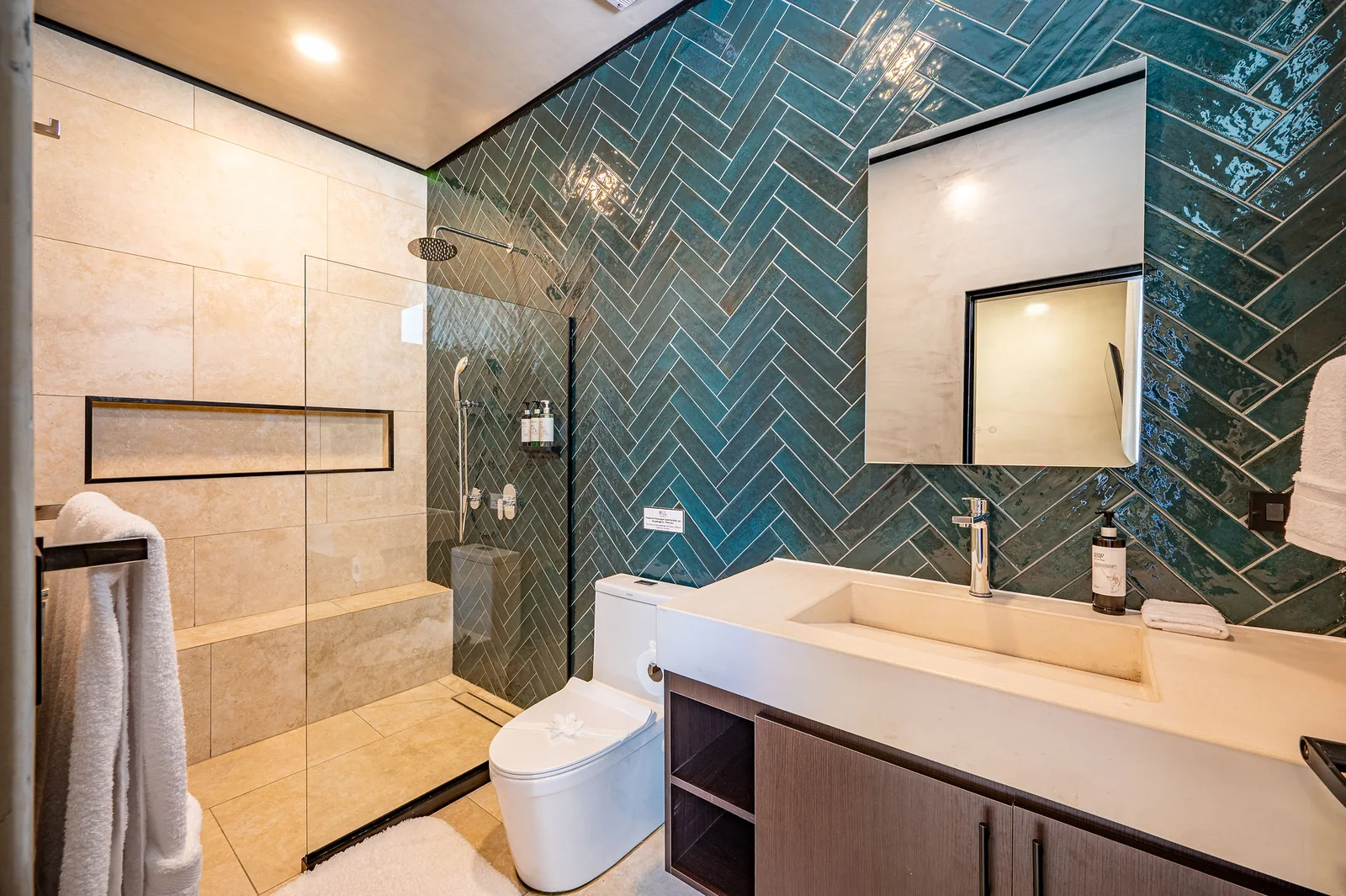Ensuite bath with teal herringbone tile