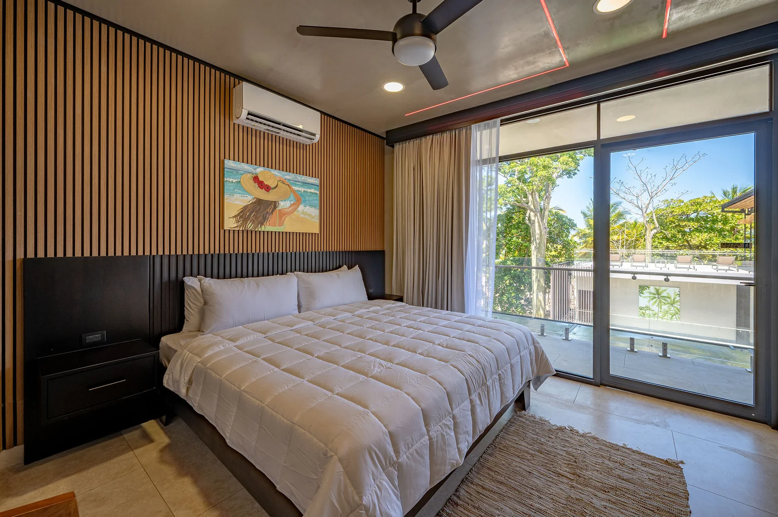 King bedroom with balcony and woven rug