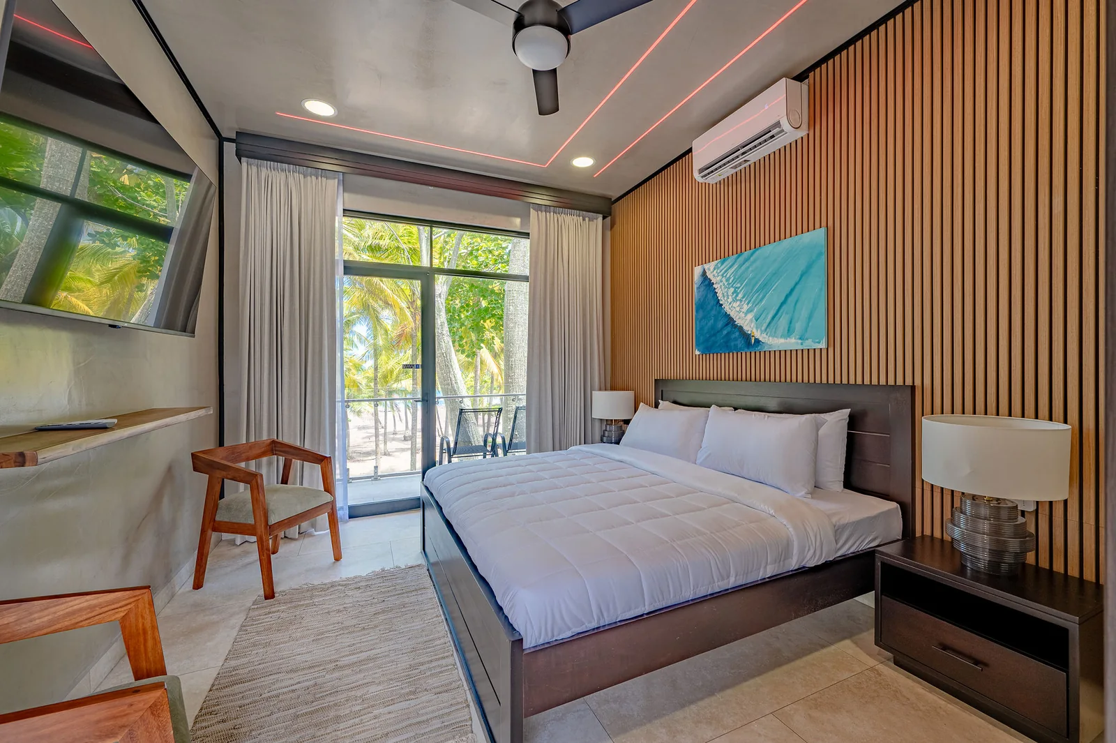 King bedroom with surf artwork and slat-wood wall